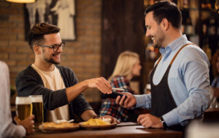 Happy,Man,Using,Smart,Phone,And,Paying,For,The,Bill